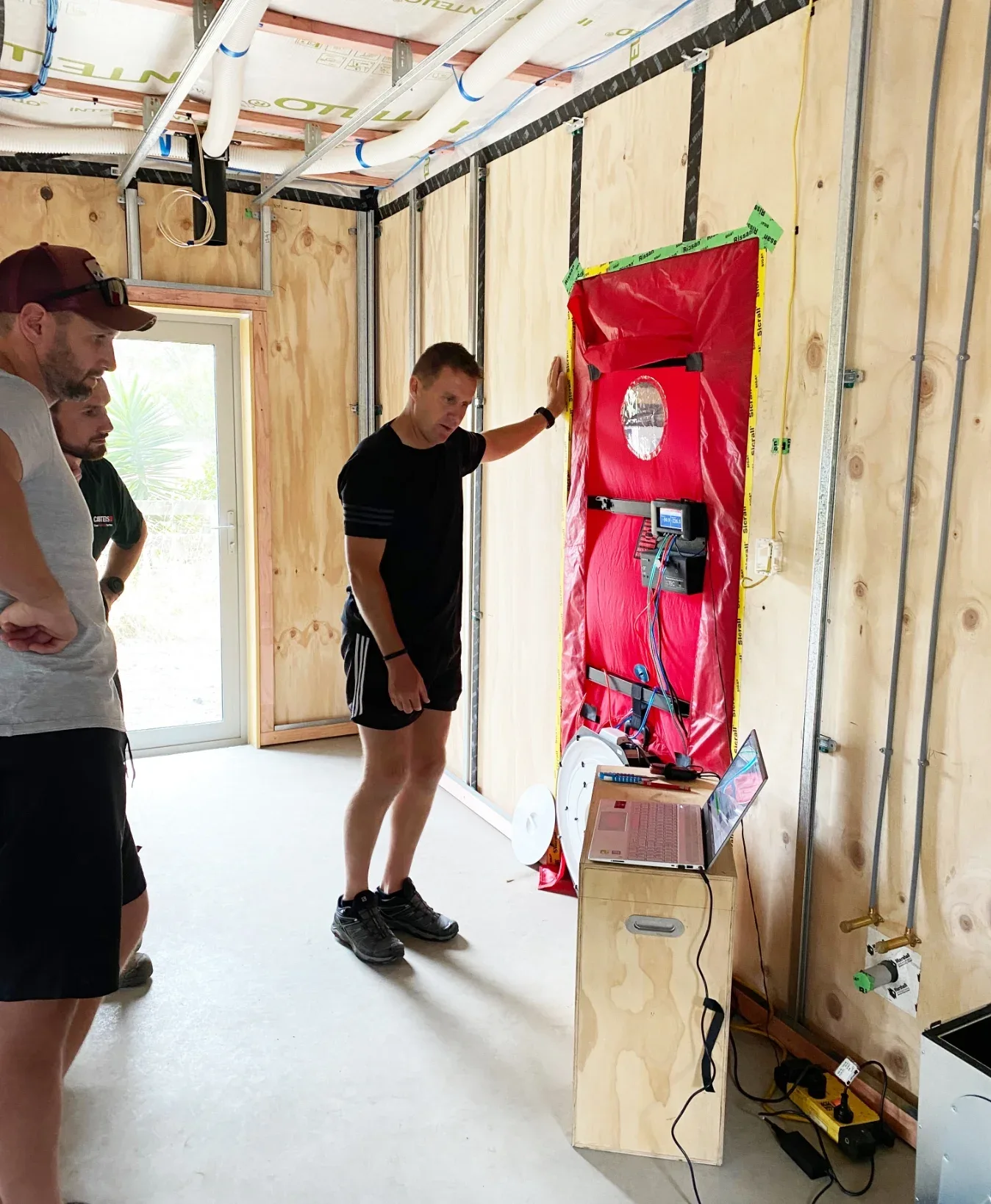 Construction workers conduct blower door testing