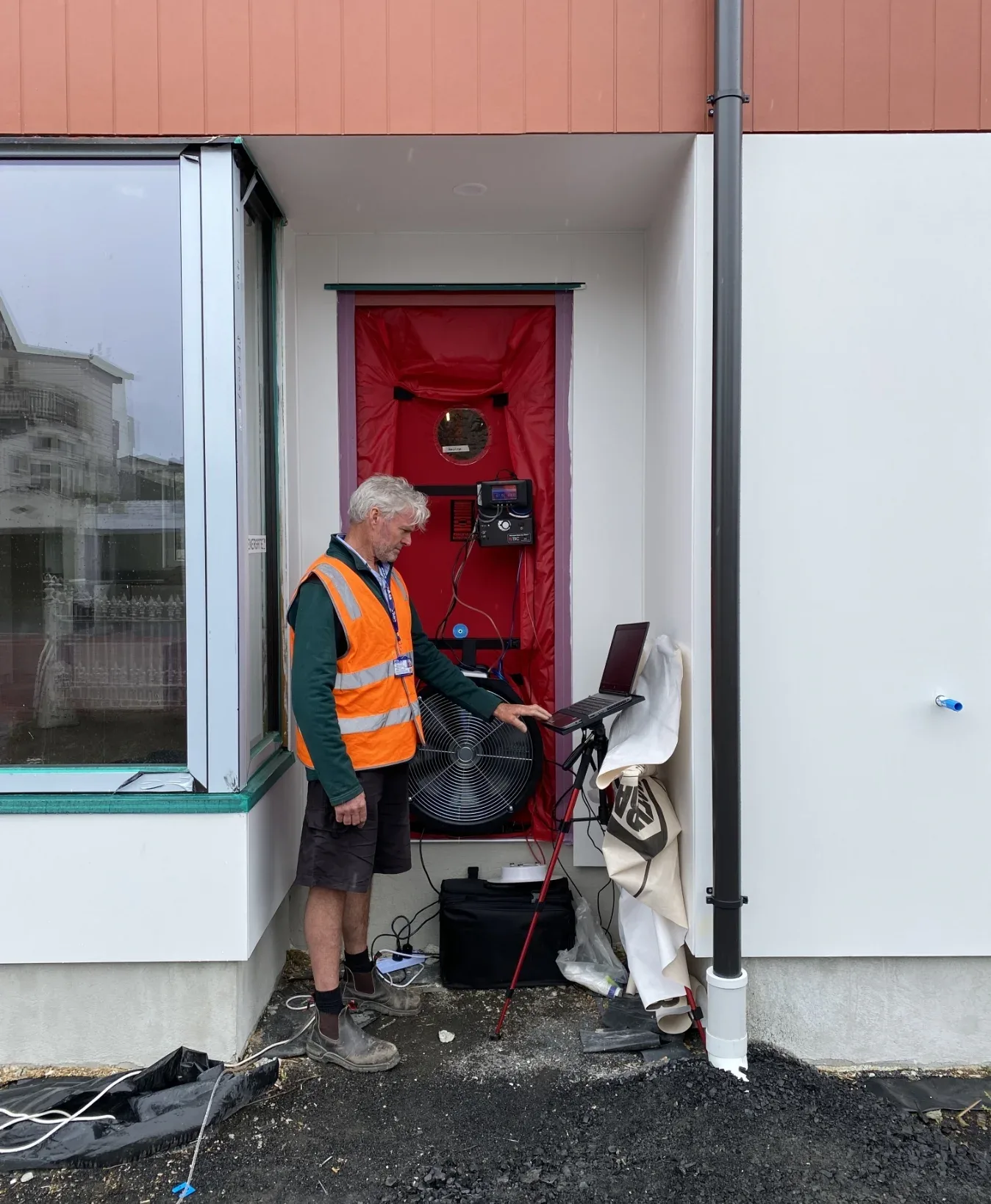 Construction worker conducts blower door testing